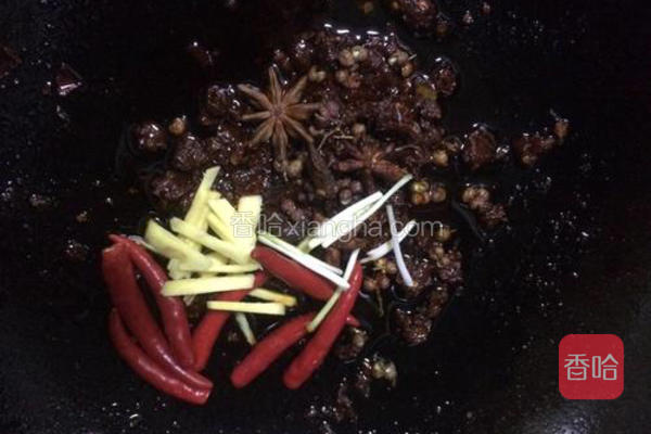  将之前准备好的葱、姜、八角、花椒和辣椒倒入锅中继续翻炒 